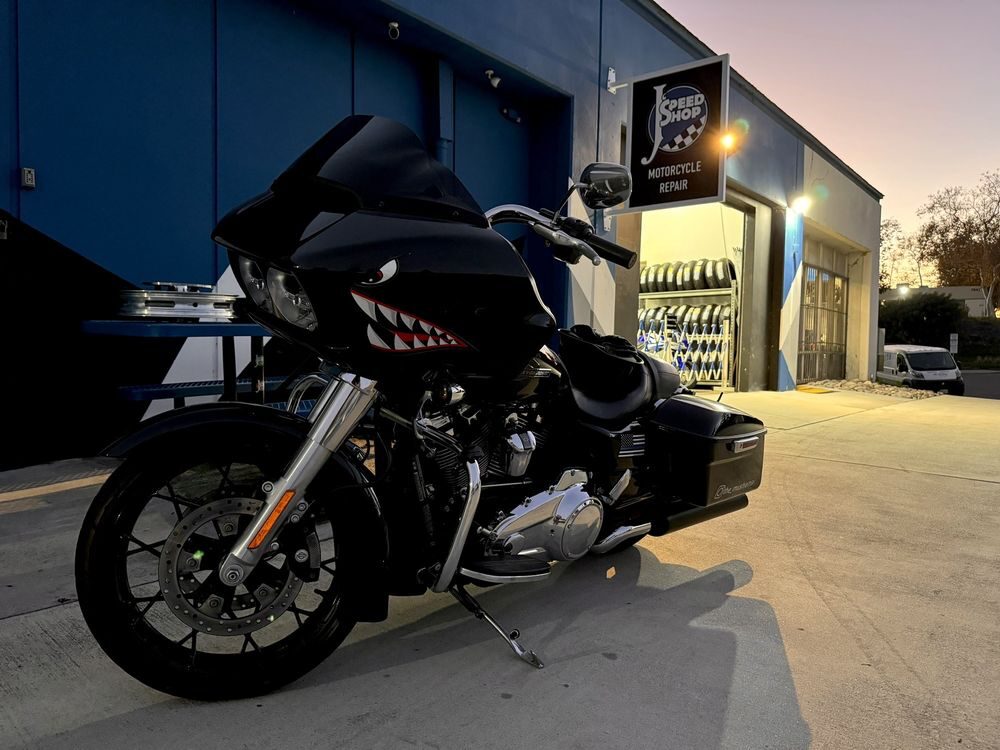 Road Glide with shark teeth graphics outside the shop at night